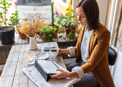 Woman reading on a tablet from a cafe